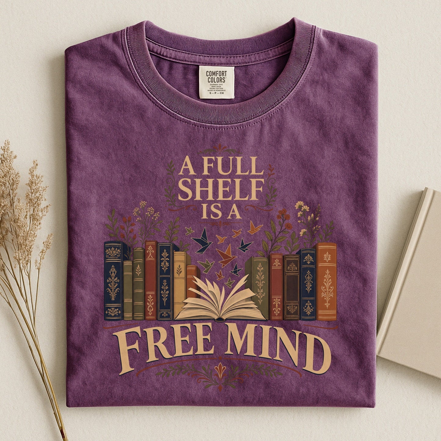 A Full Shelf Is a Free Mind bookish tee in Berry, flat lay