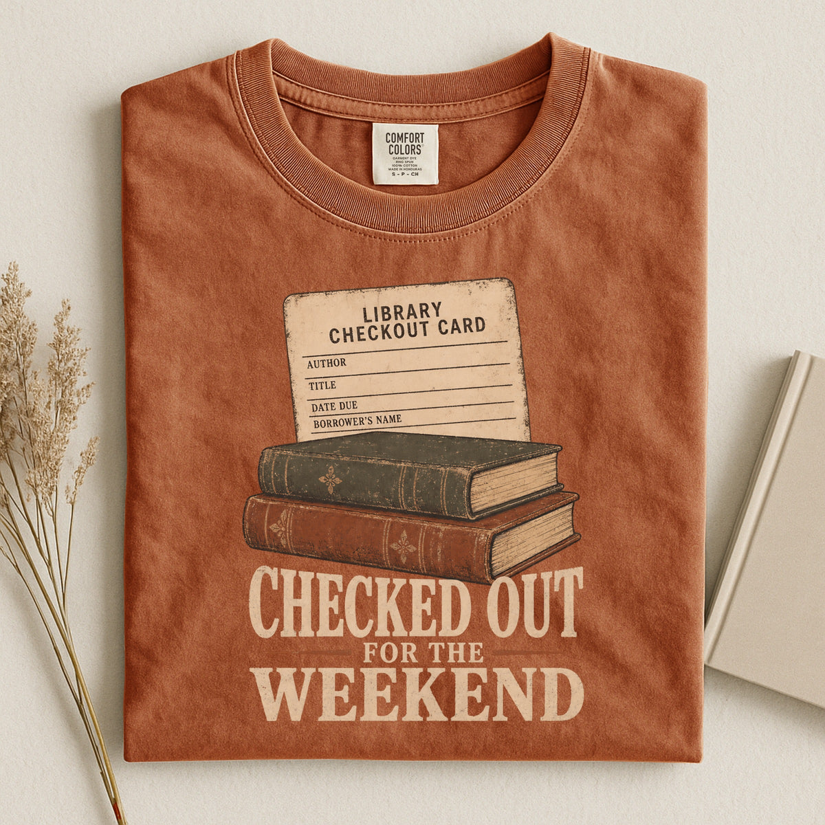 Shelf Love Studio Checked Out for the Weekend t-shirt in Yam, styled flat lay