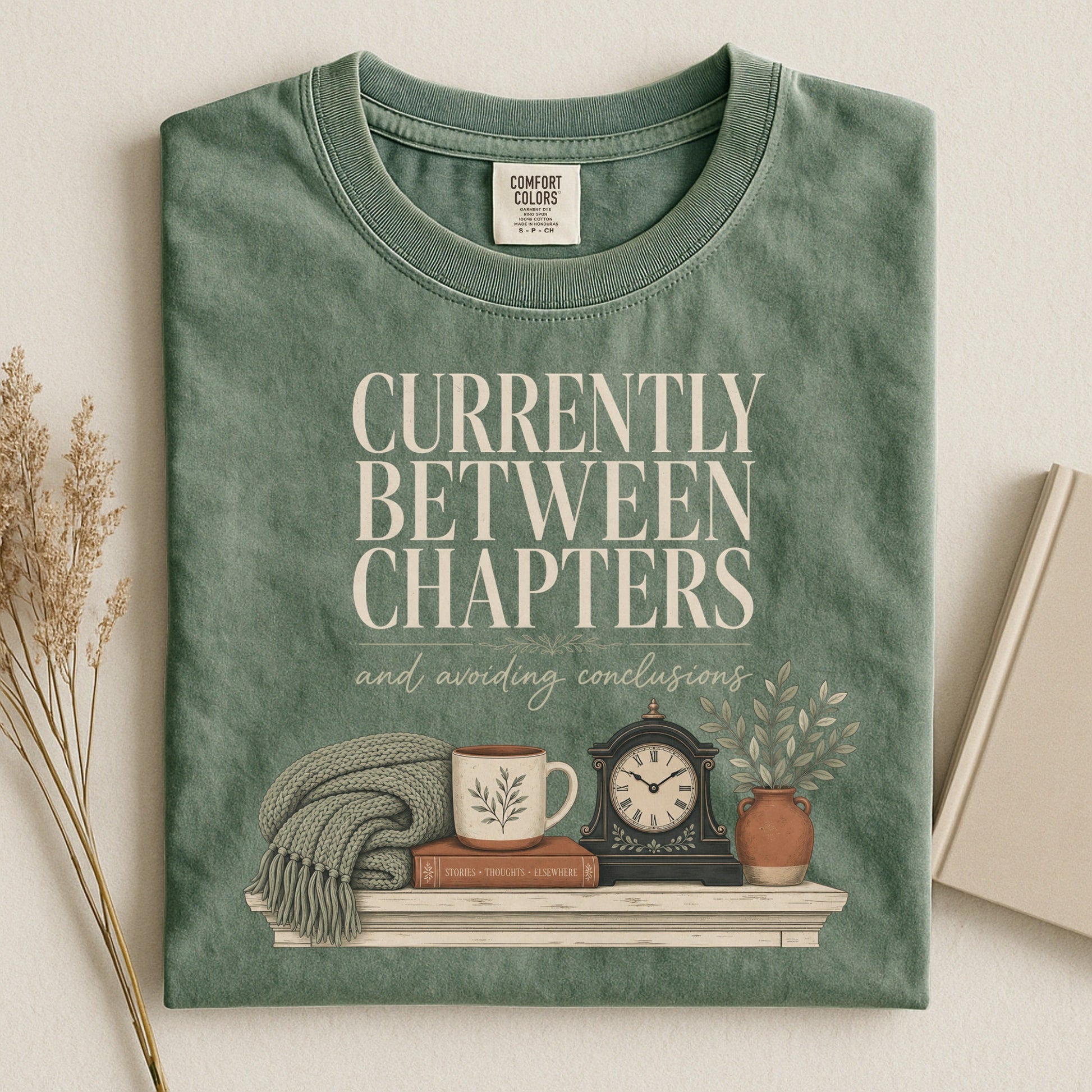 Currently Between Chapters bookish tee in Moss, flat lay