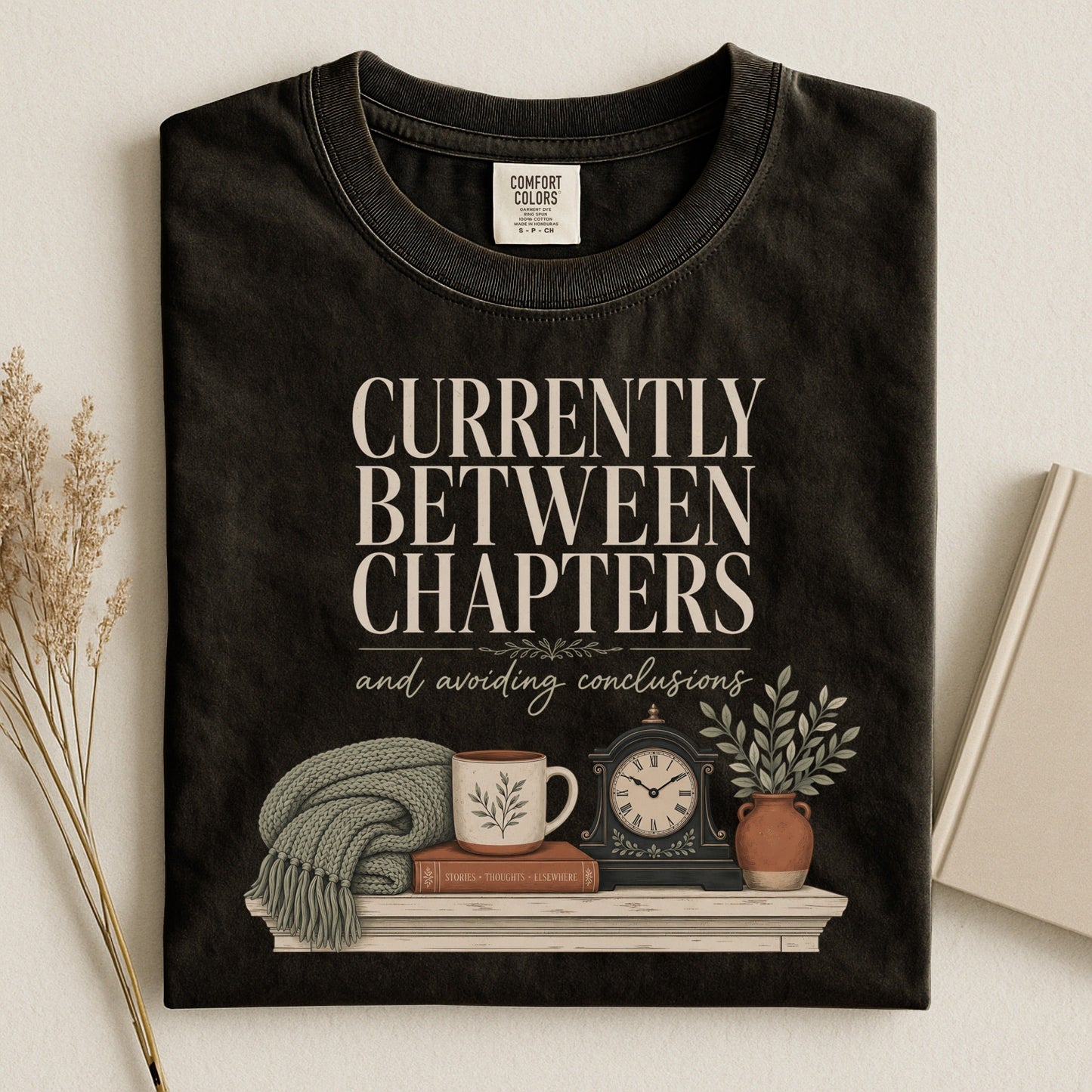 Currently Between Chapters bookish tee in Black, flat lay