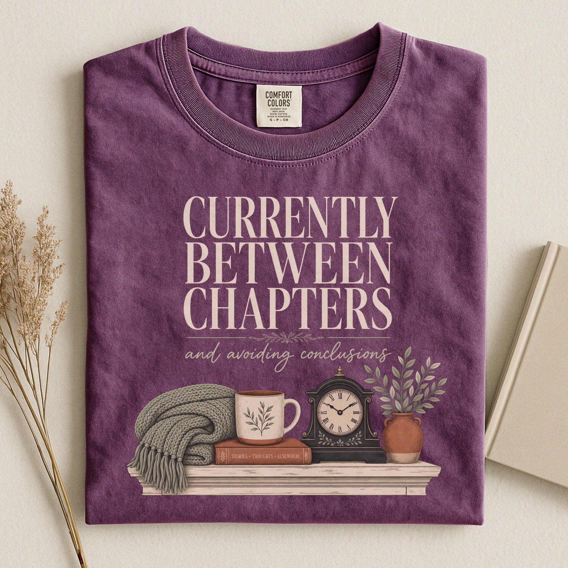 Currently Between Chapters bookish tee in Berry, flat lay