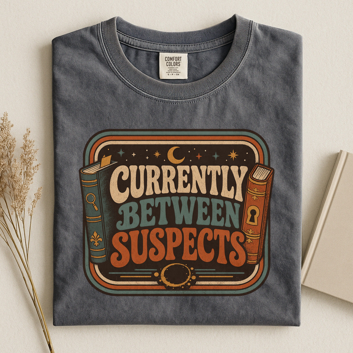 Shelf Love Studio Currently Between Suspects t-shirt in Pepper, styled flat lay