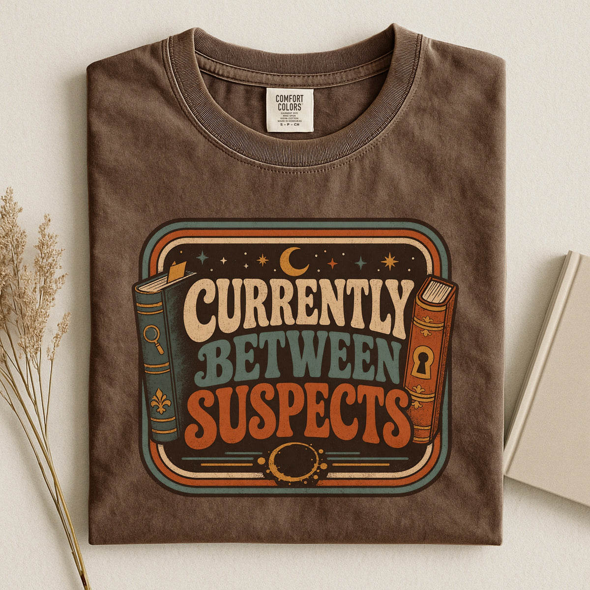 Shelf Love Studio Currently Between Suspects t-shirt in Espresso, styled flat lay