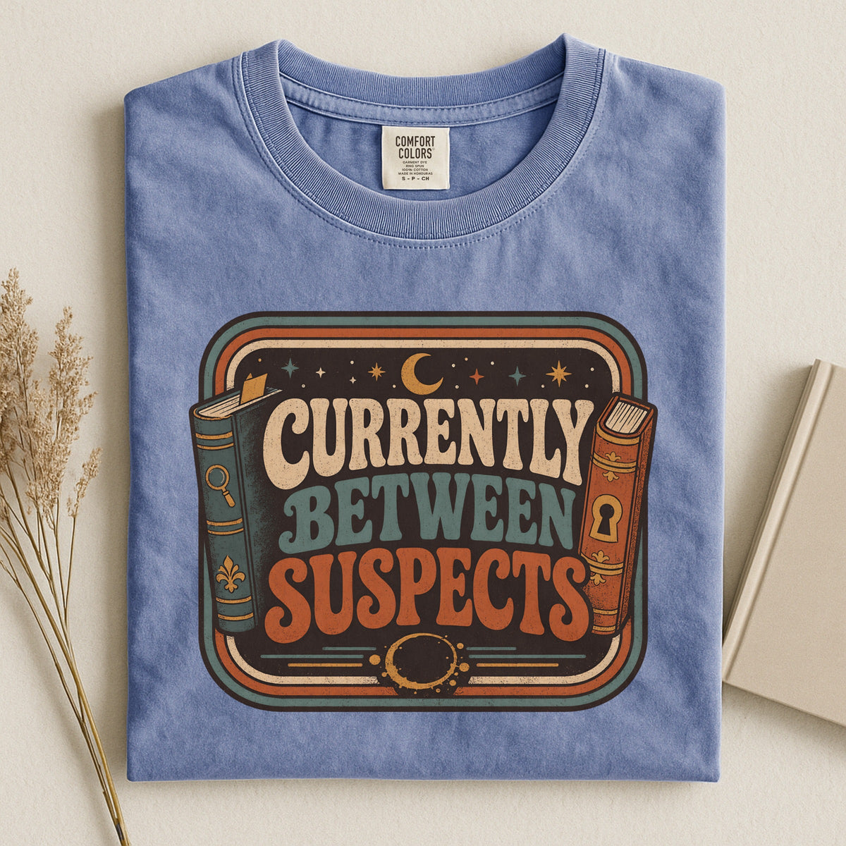 Shelf Love Studio Currently Between Suspects t-shirt in Blue Jean, styled flat lay