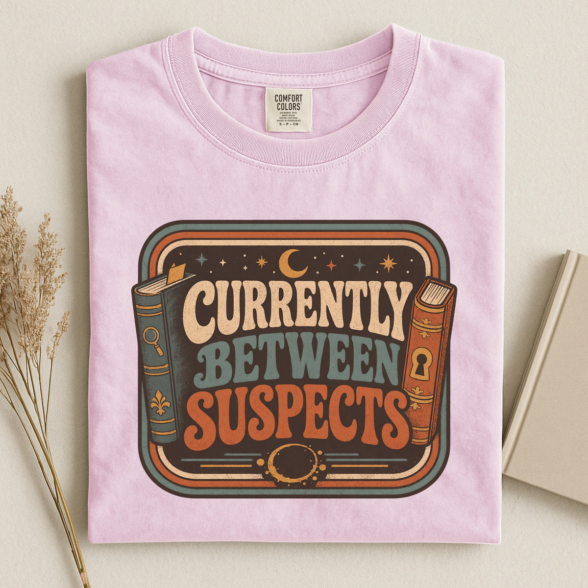 Shelf Love Studio Currently Between Suspects t-shirt in Blossom, styled flat lay