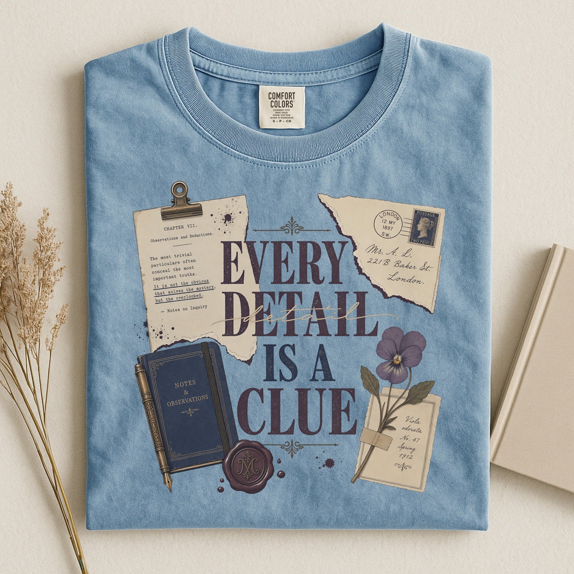 Every Detail Is a Clue bookish tee in Ice Blue, flat lay