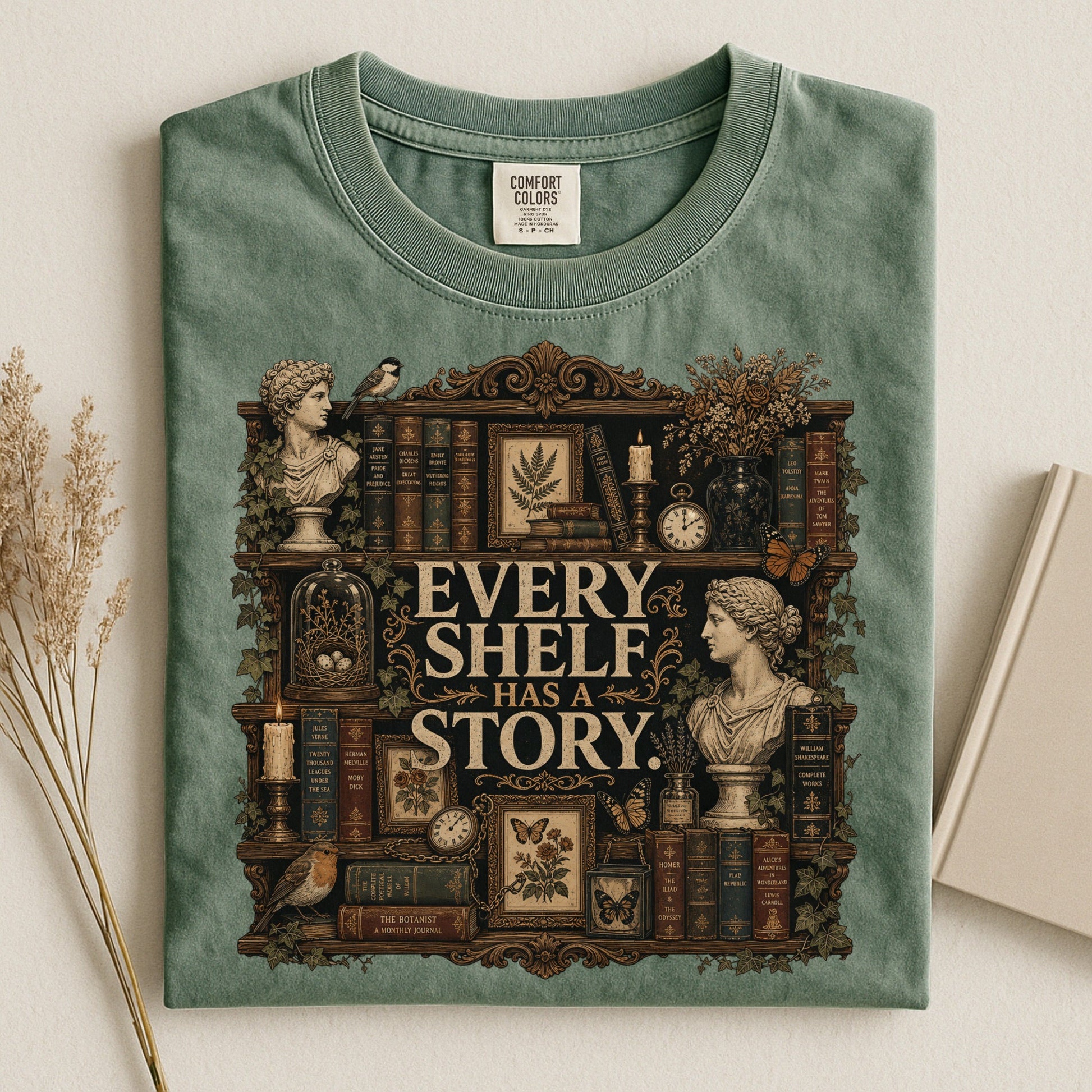 Every Shelf Has a Story bookish tee in Moss, flat lay