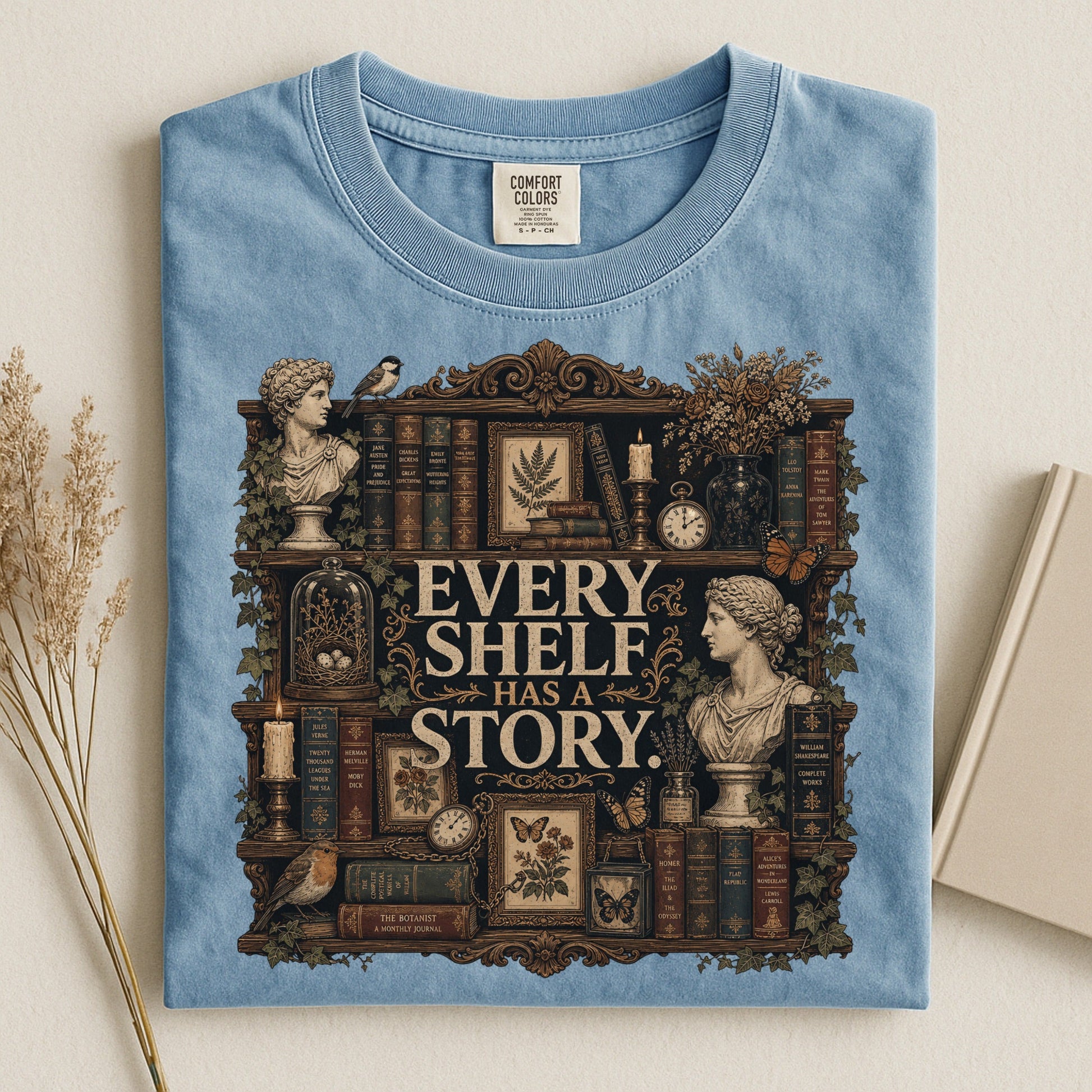 Every Shelf Has a Story bookish tee in Ice Blue, flat lay