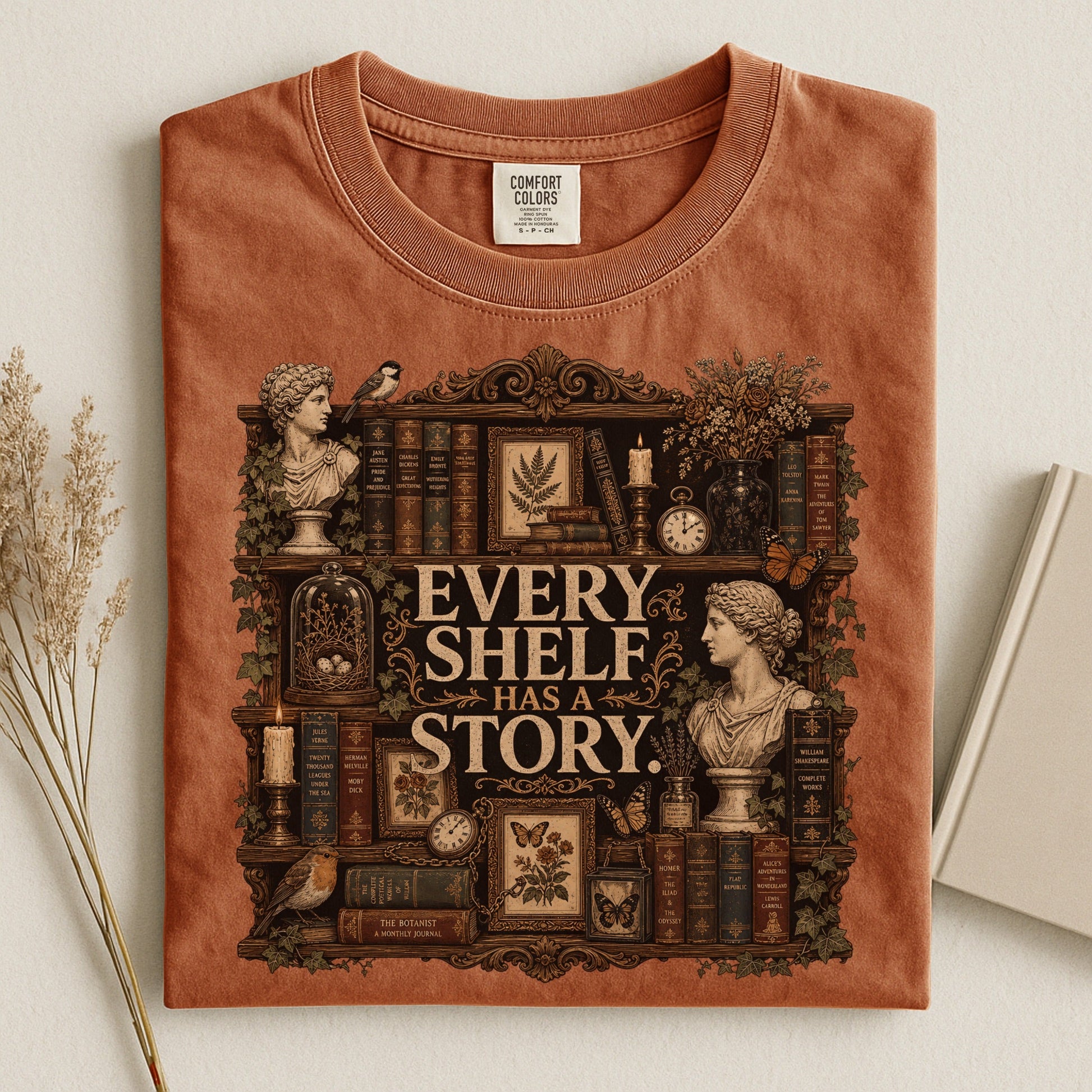 Every Shelf Has a Story bookish tee in Yam, flat lay