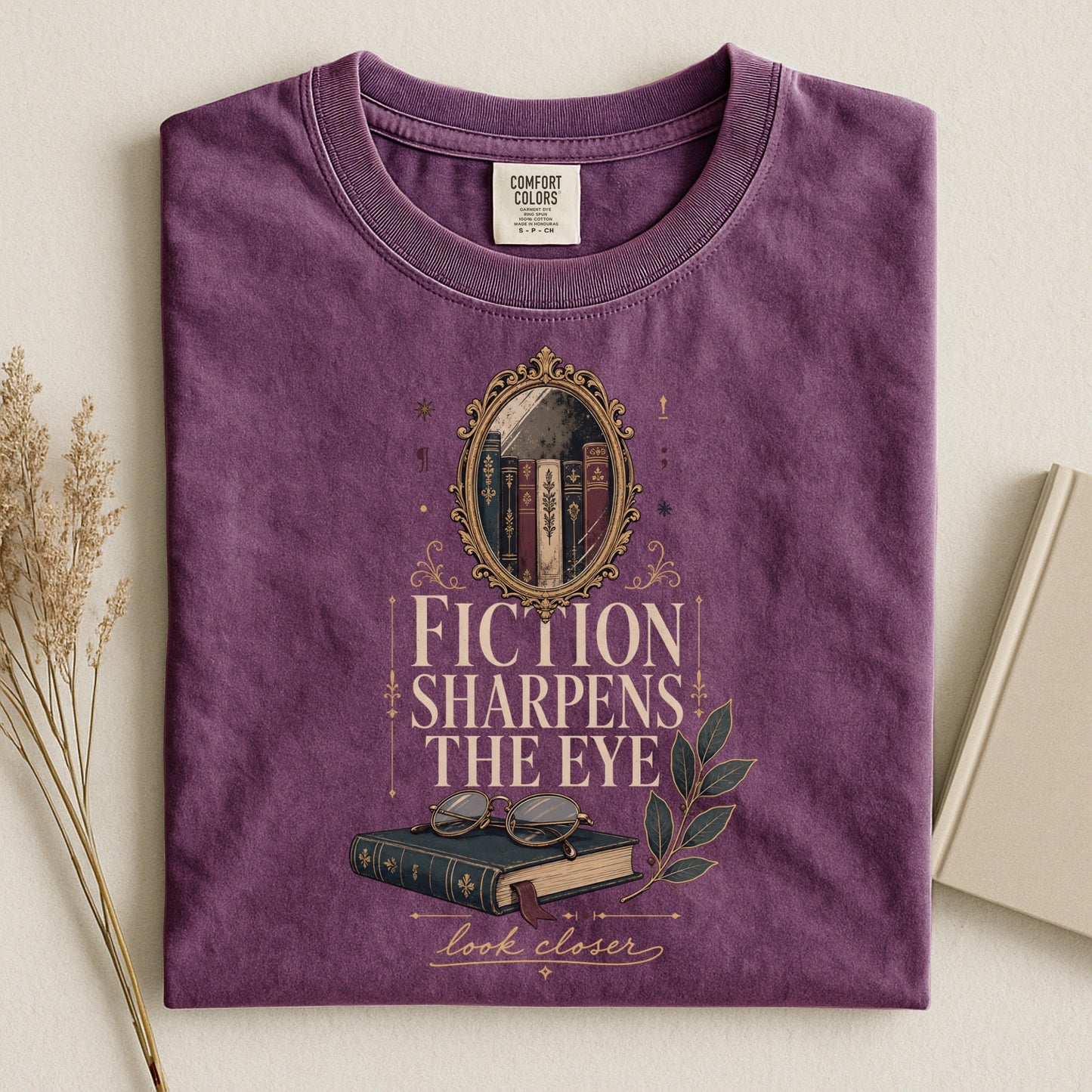Fiction Sharpens the Eye bookish tee in Berry, flat lay