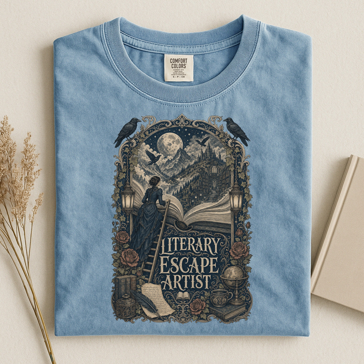 Literary Escape Artist bookish tee in Ice Blue, flat lay
