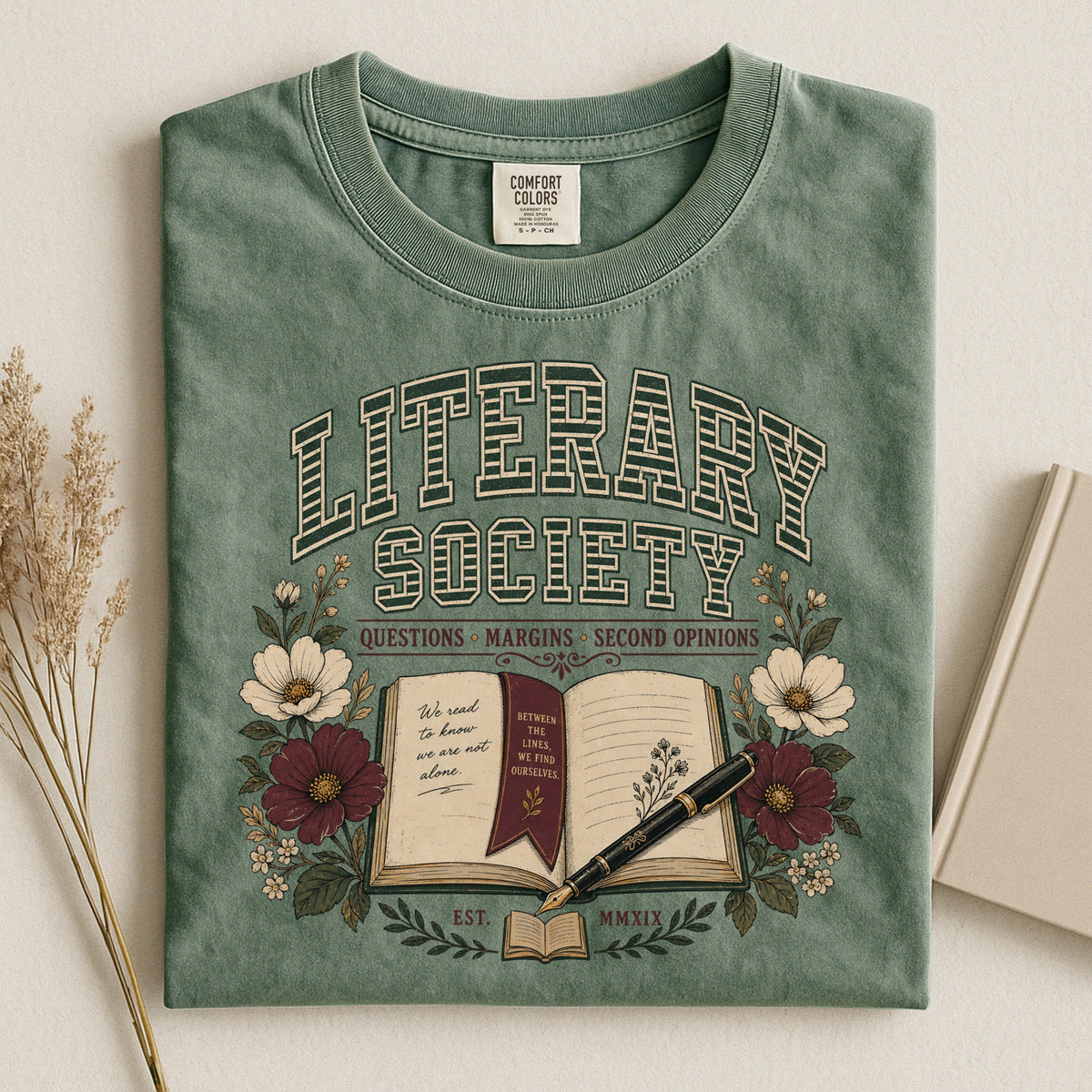 Shelf Love Studio Literary Society t-shirt in Moss, styled flat lay
