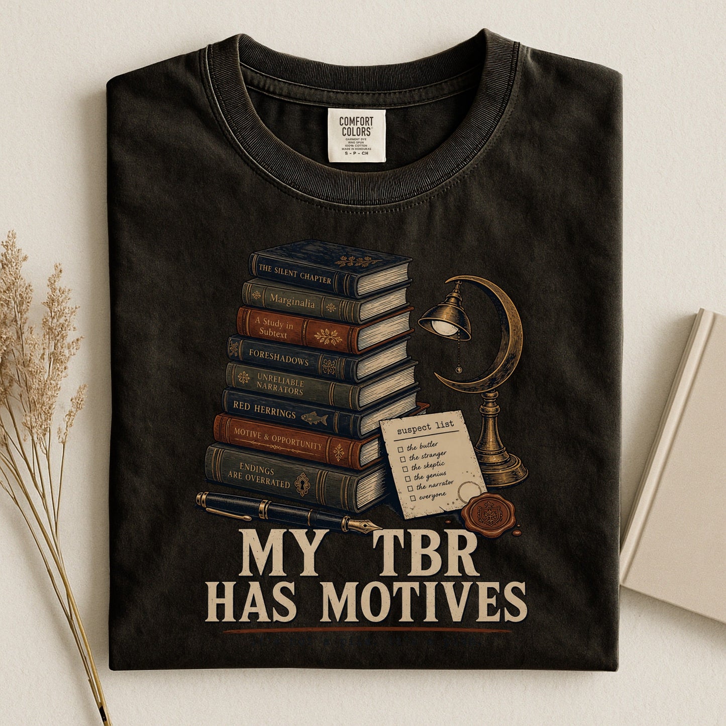 My TBR Has Motives bookish tee in Black, flat lay