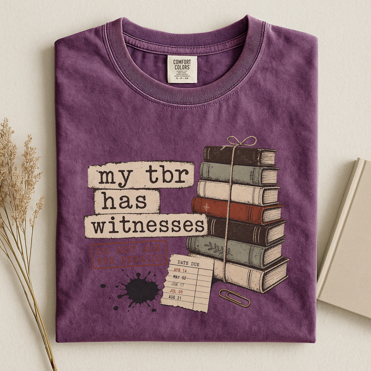 Shelf Love Studio My TBR Has Witnesses t-shirt in Berry, styled flat lay
