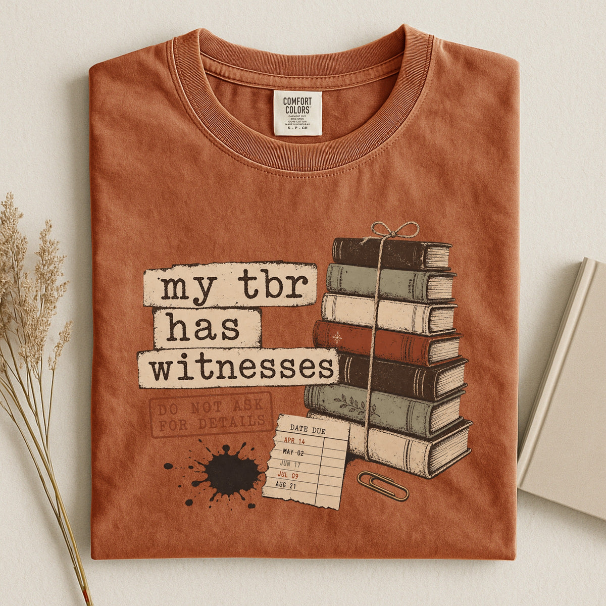 Shelf Love Studio My TBR Has Witnesses t-shirt in Yam, styled flat lay