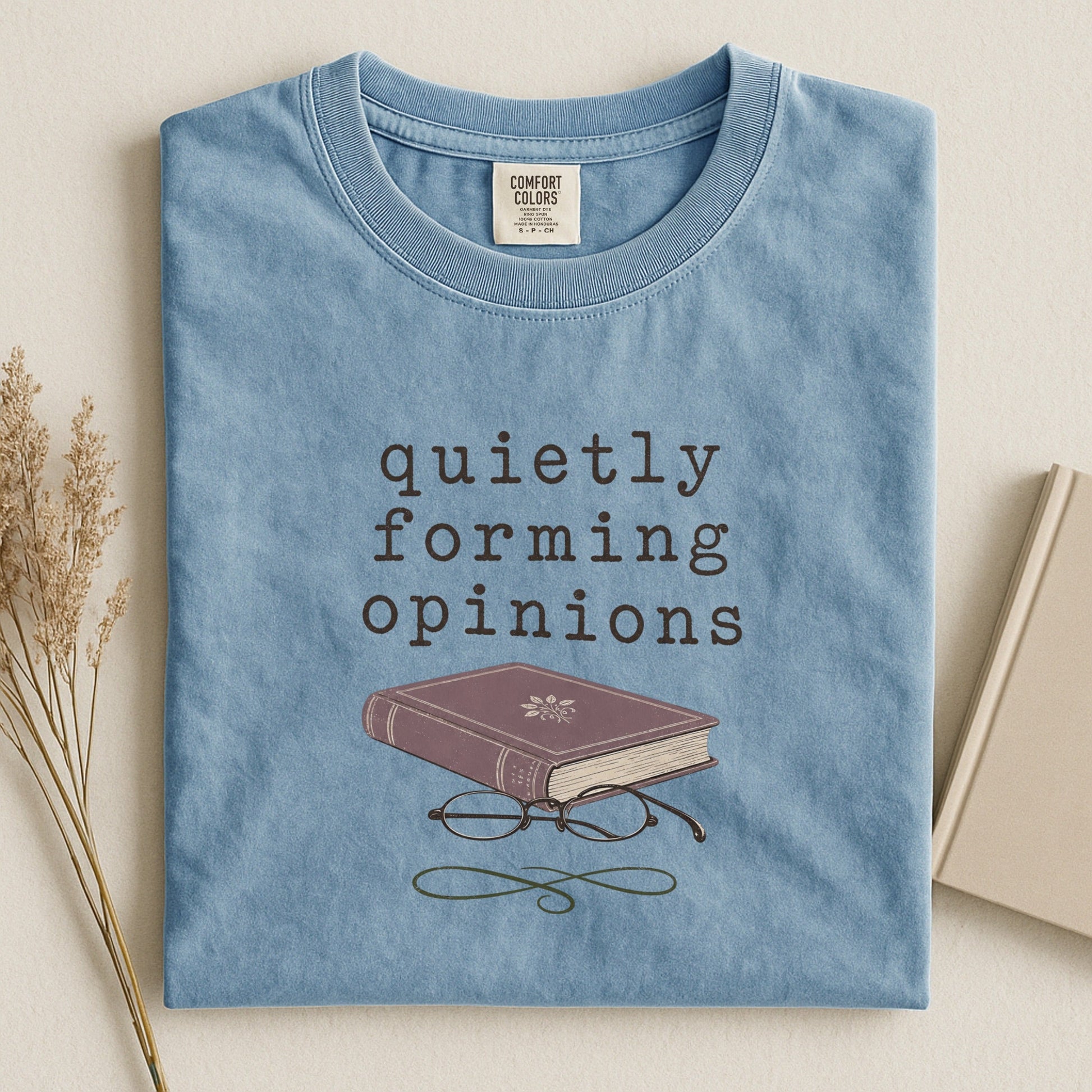 Quietly Forming Opinions bookish tee in Ice Blue, flat lay