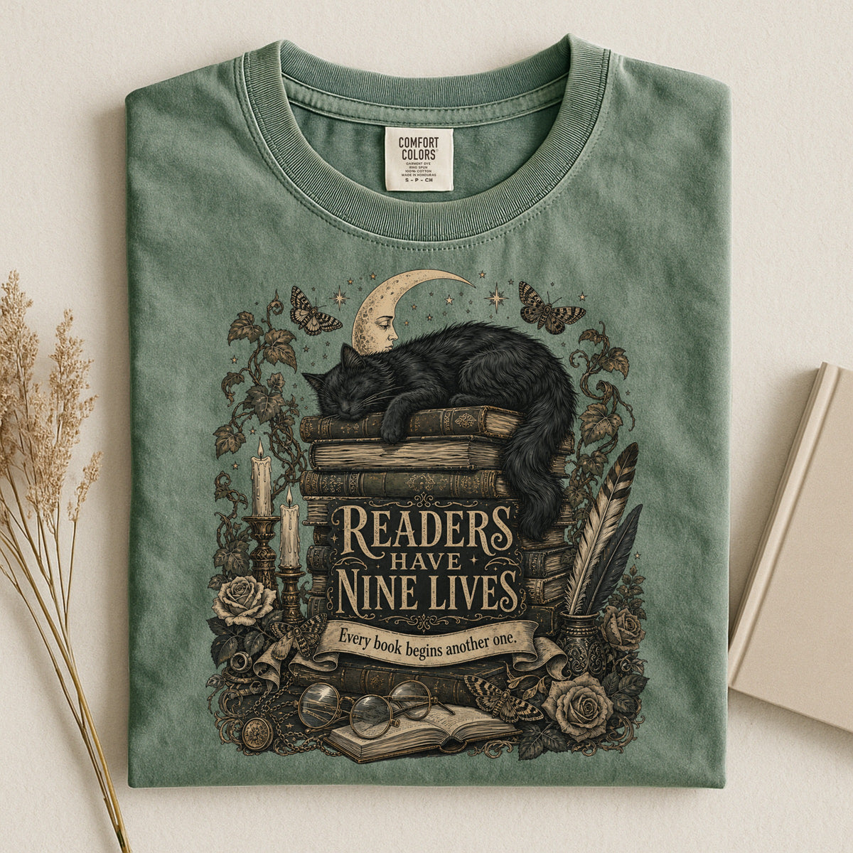 Readers Have Nine Lives bookish tee in Moss, flat lay