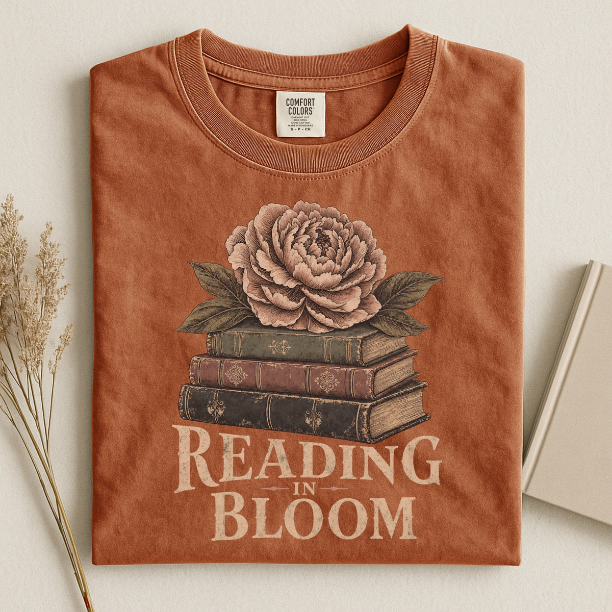 Shelf Love Studio Reading in Bloom t-shirt in Yam, styled flat lay