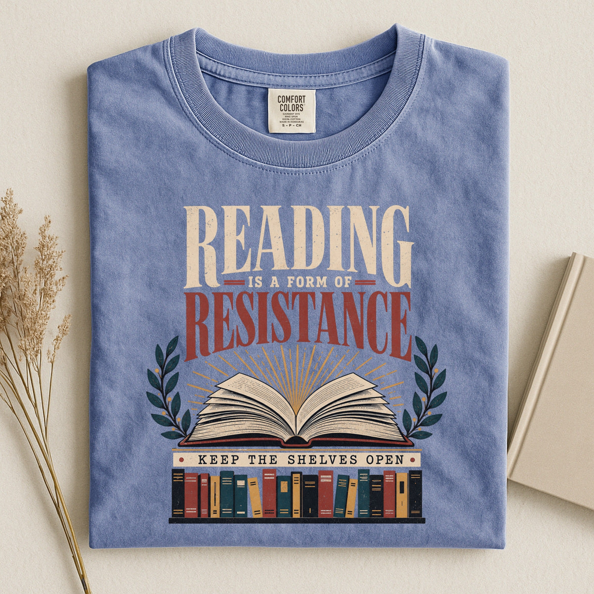 Shelf Love Studio Reading Is a Form of Resistance t-shirt in Blue Jean, styled flat lay