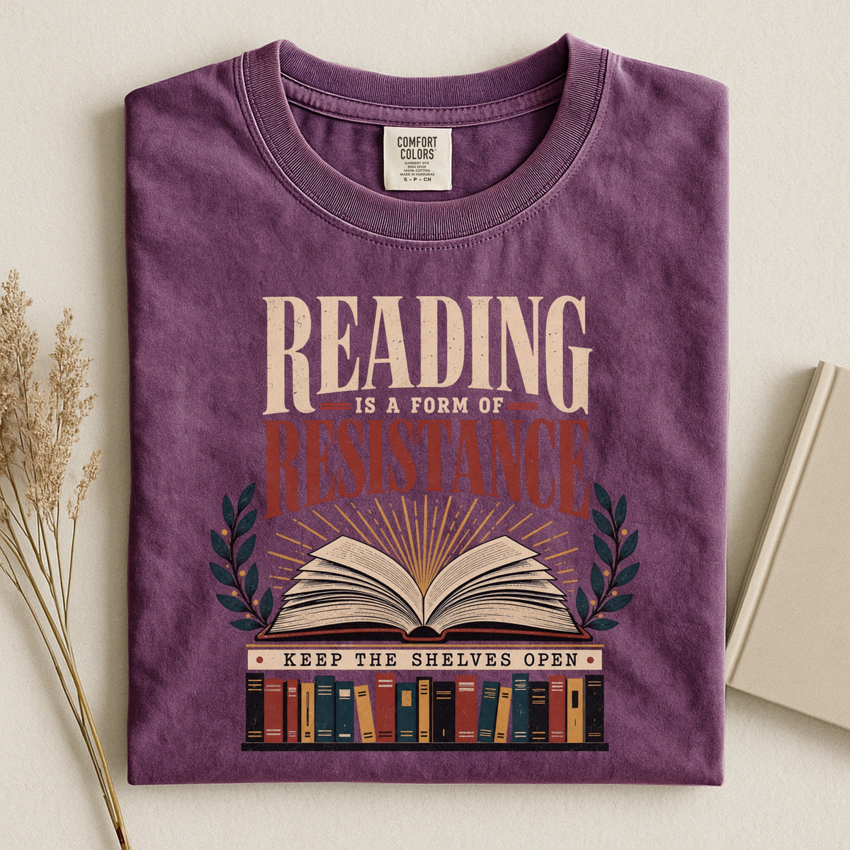 Shelf Love Studio Reading Is a Form of Resistance t-shirt in Berry, styled flat lay