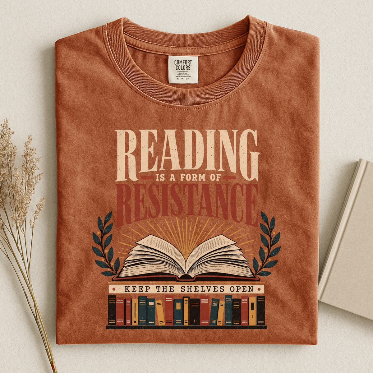 Shelf Love Studio Reading Is a Form of Resistance t-shirt in Yam, styled flat lay
