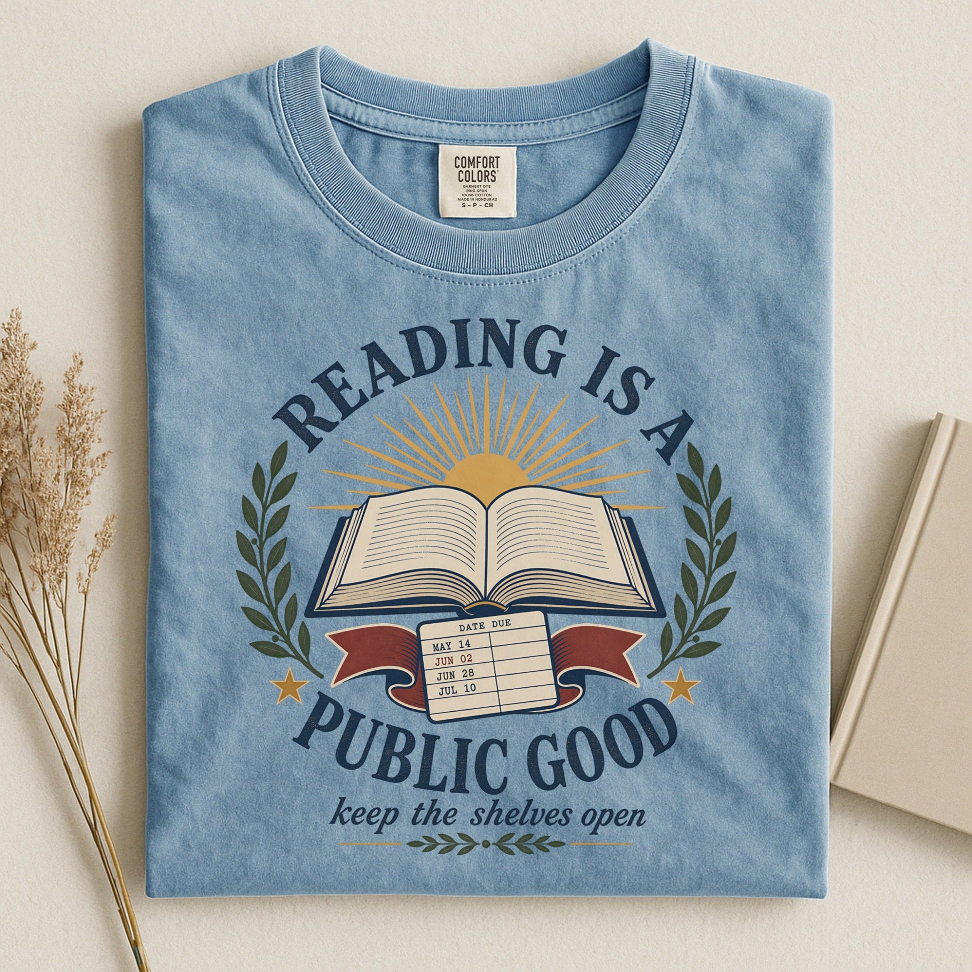 Reading Is a Public Good bookish tee in Ice Blue, flat lay