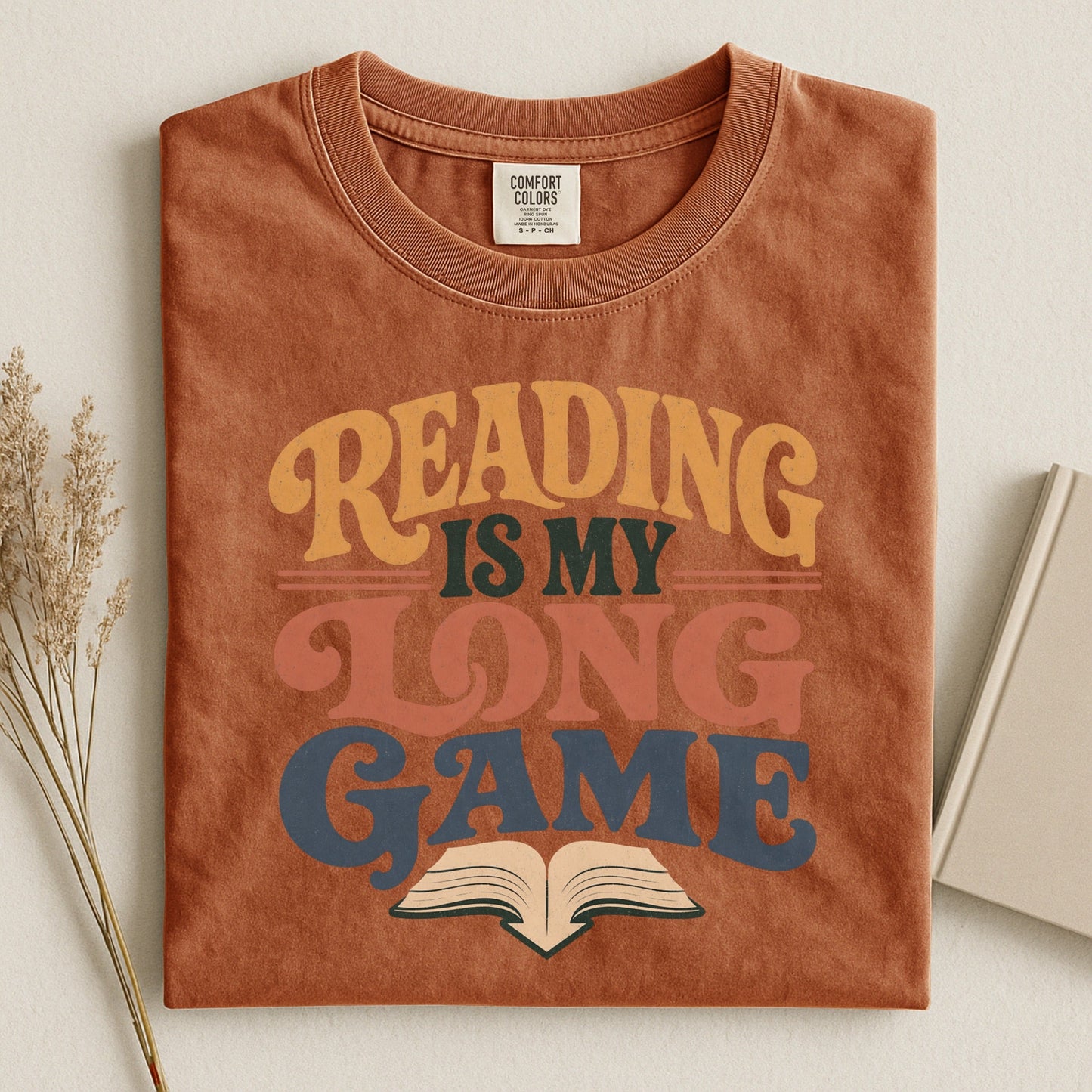 Reading Is My Long Game bookish tee in Yam, flat lay