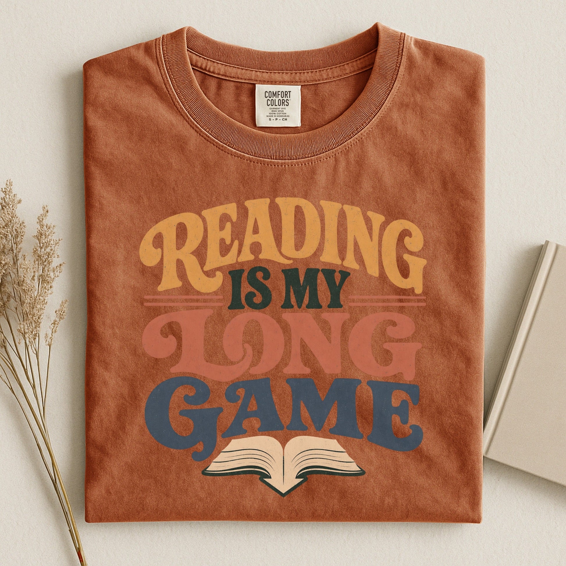 Reading Is My Long Game bookish tee in Yam, flat lay