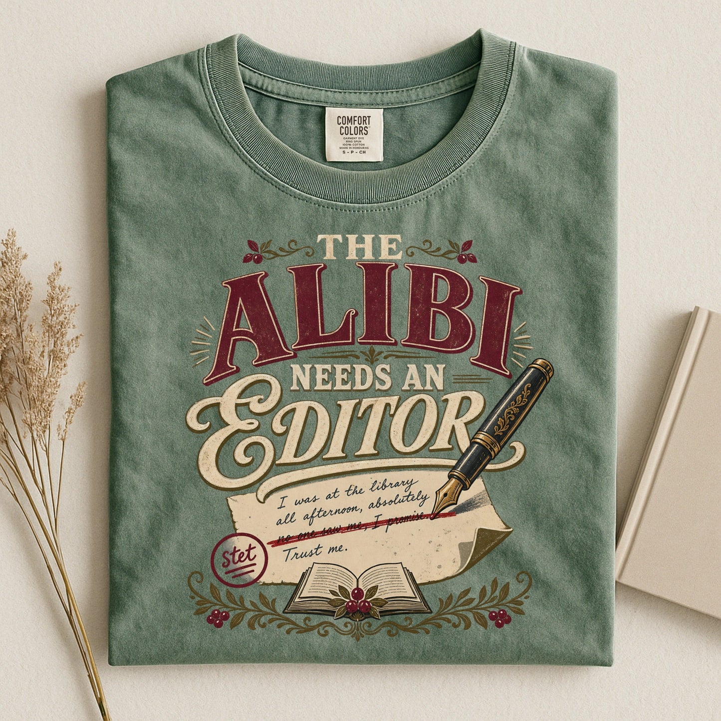 The Alibi Needs an Editor bookish tee in Moss, flat lay