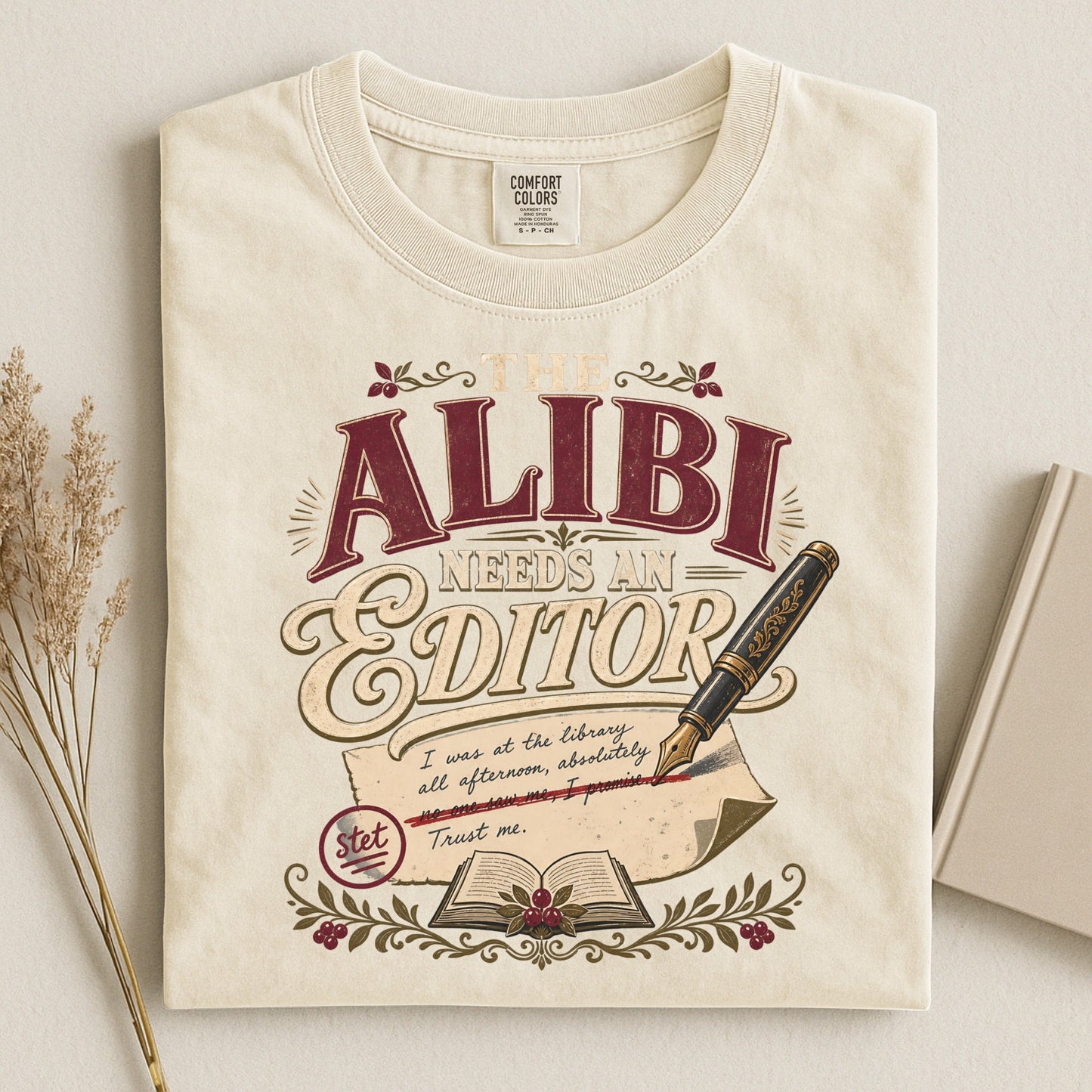 The Alibi Needs an Editor bookish tee in Ivory, flat lay