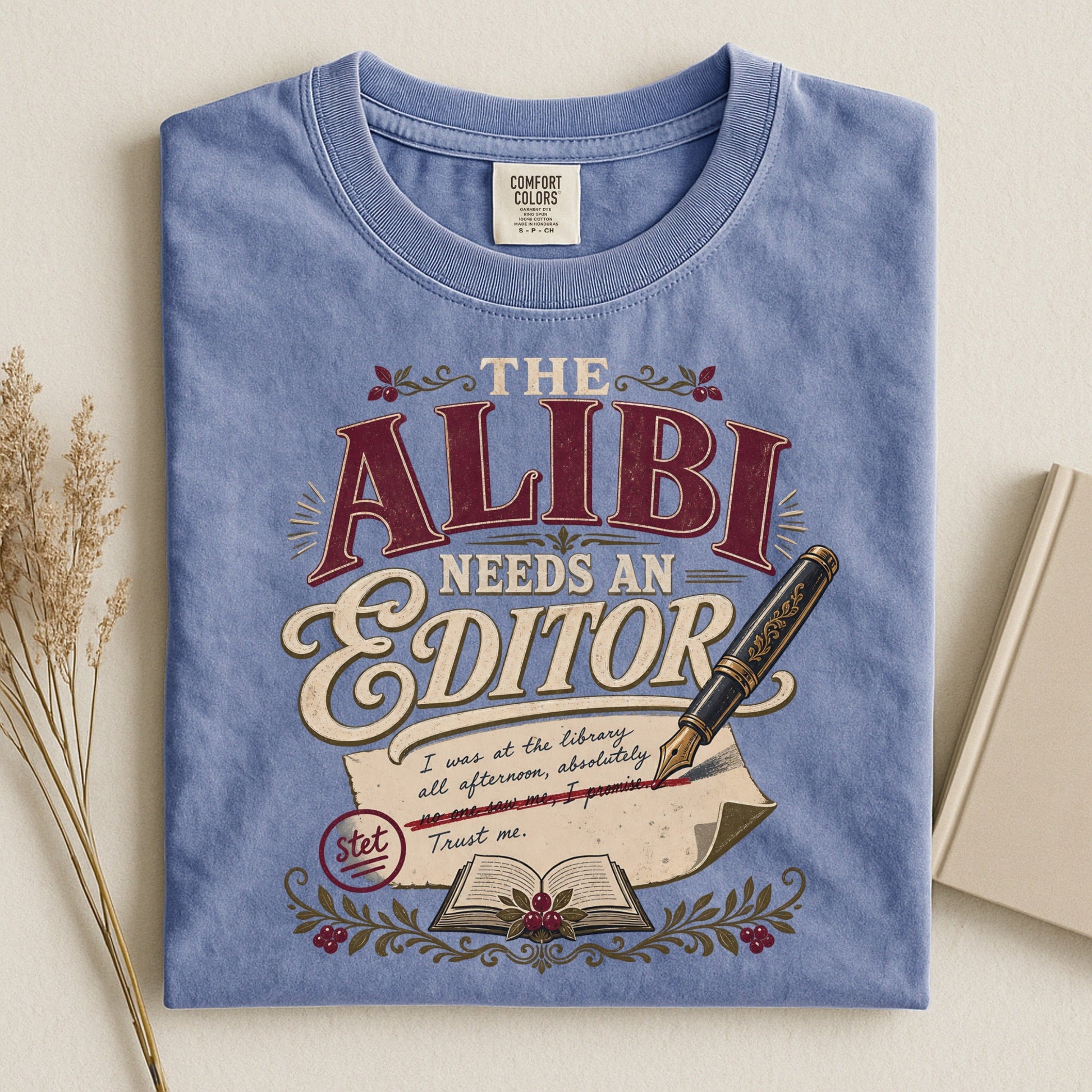 The Alibi Needs an Editor bookish tee in Blue Jean, flat lay