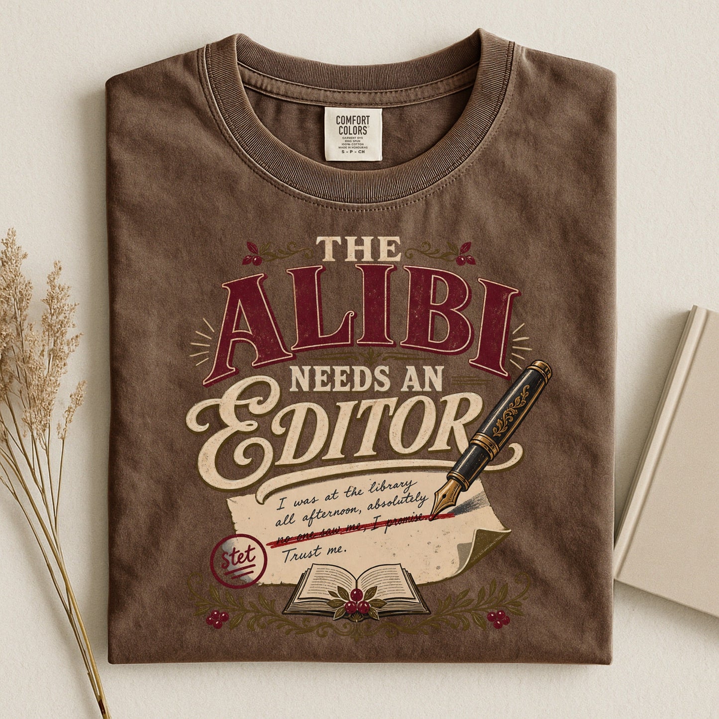 The Alibi Needs an Editor bookish tee in Espresso, flat lay