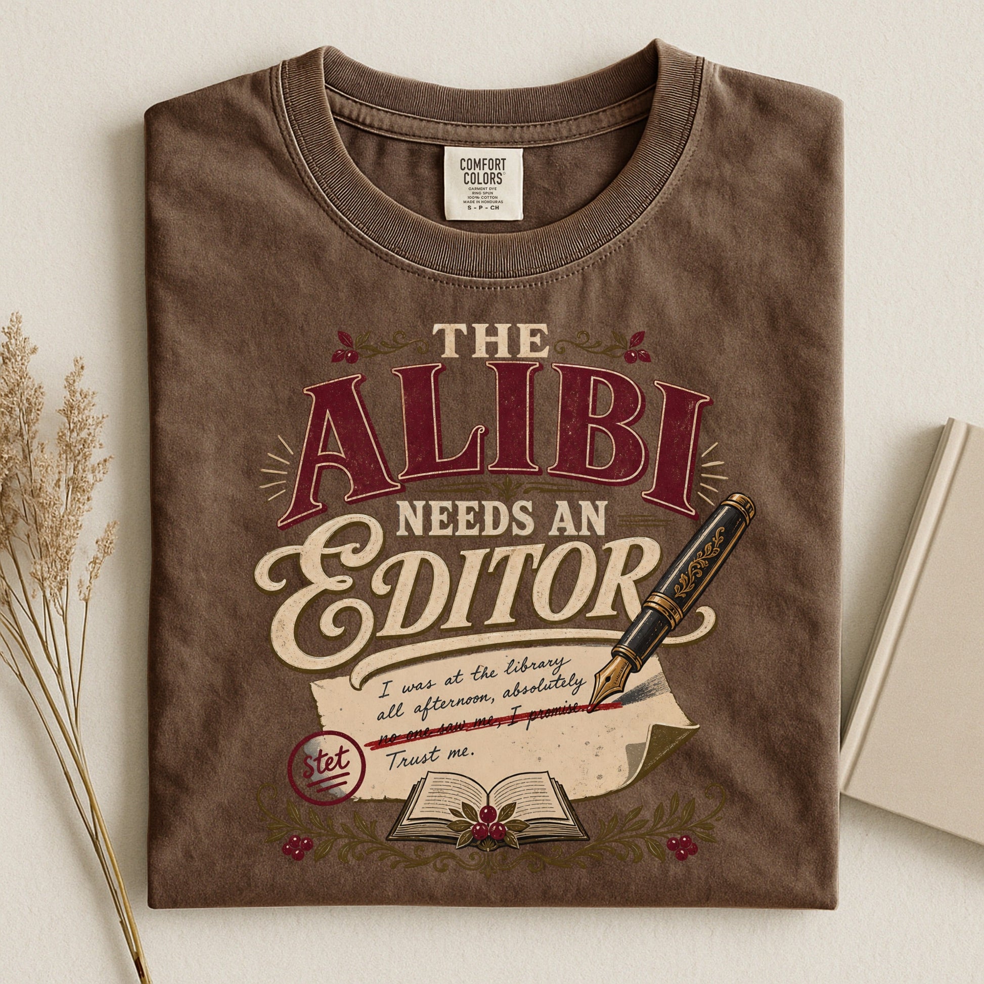 The Alibi Needs an Editor bookish tee in Espresso, flat lay