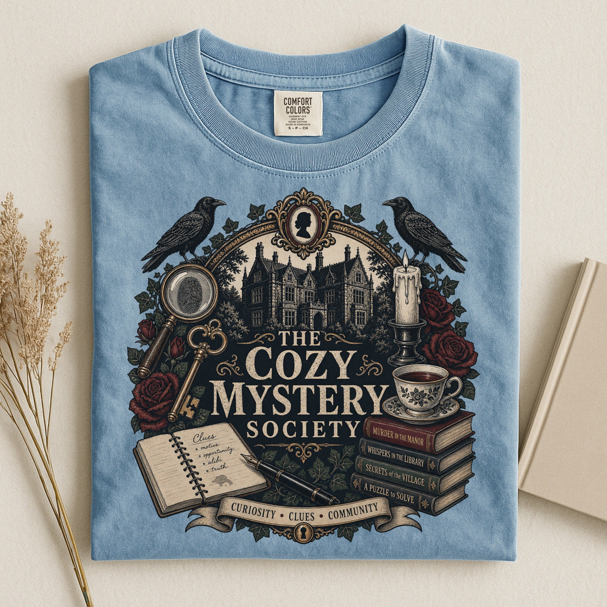 The Cozy Mystery Society bookish tee in Ice Blue, flat lay