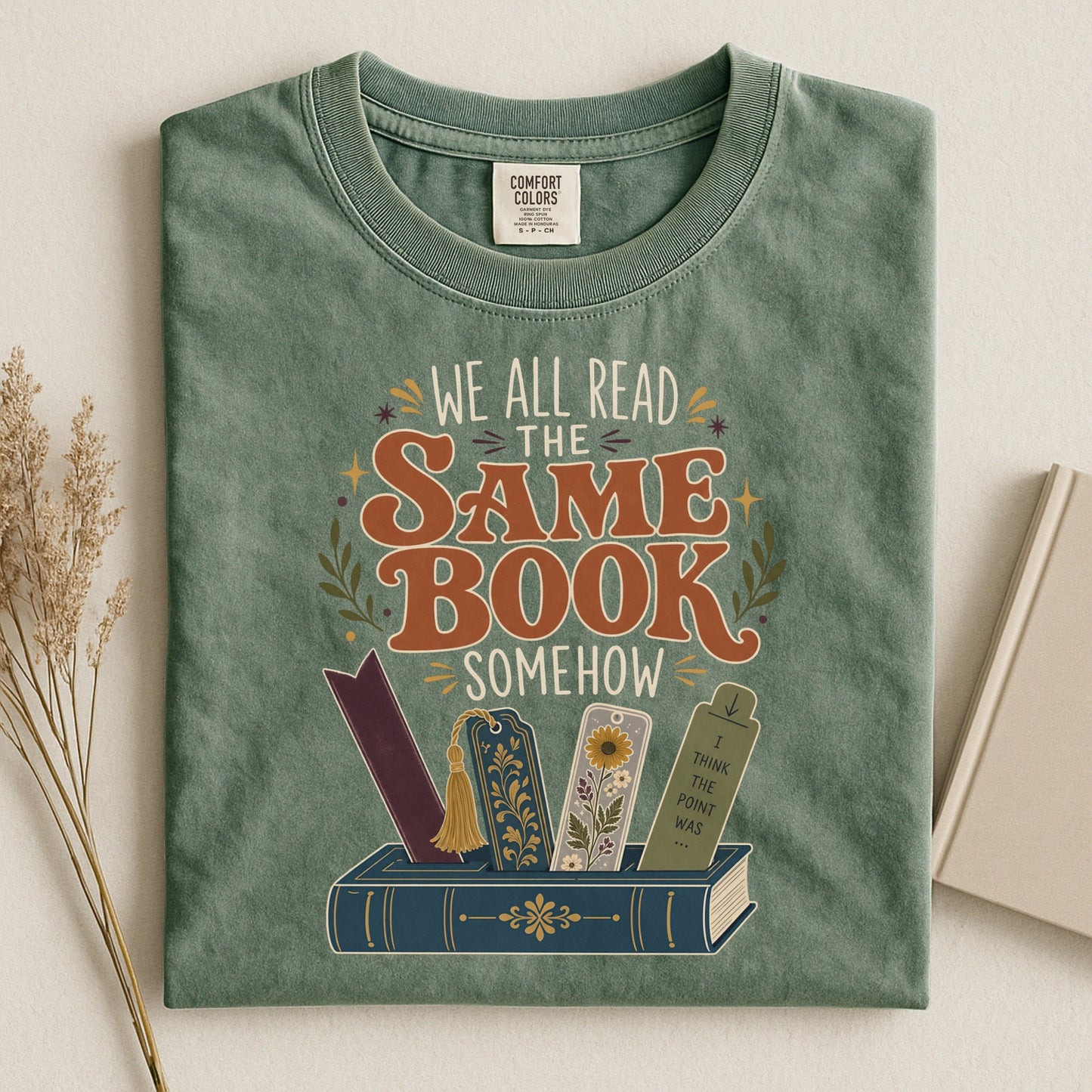 We All Read the Same Book Somehow bookish tee in Moss, flat lay